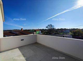 Geräumiger Balkon mit weitem Blick über die Dächer der Umgebung und den blauen Himmel.