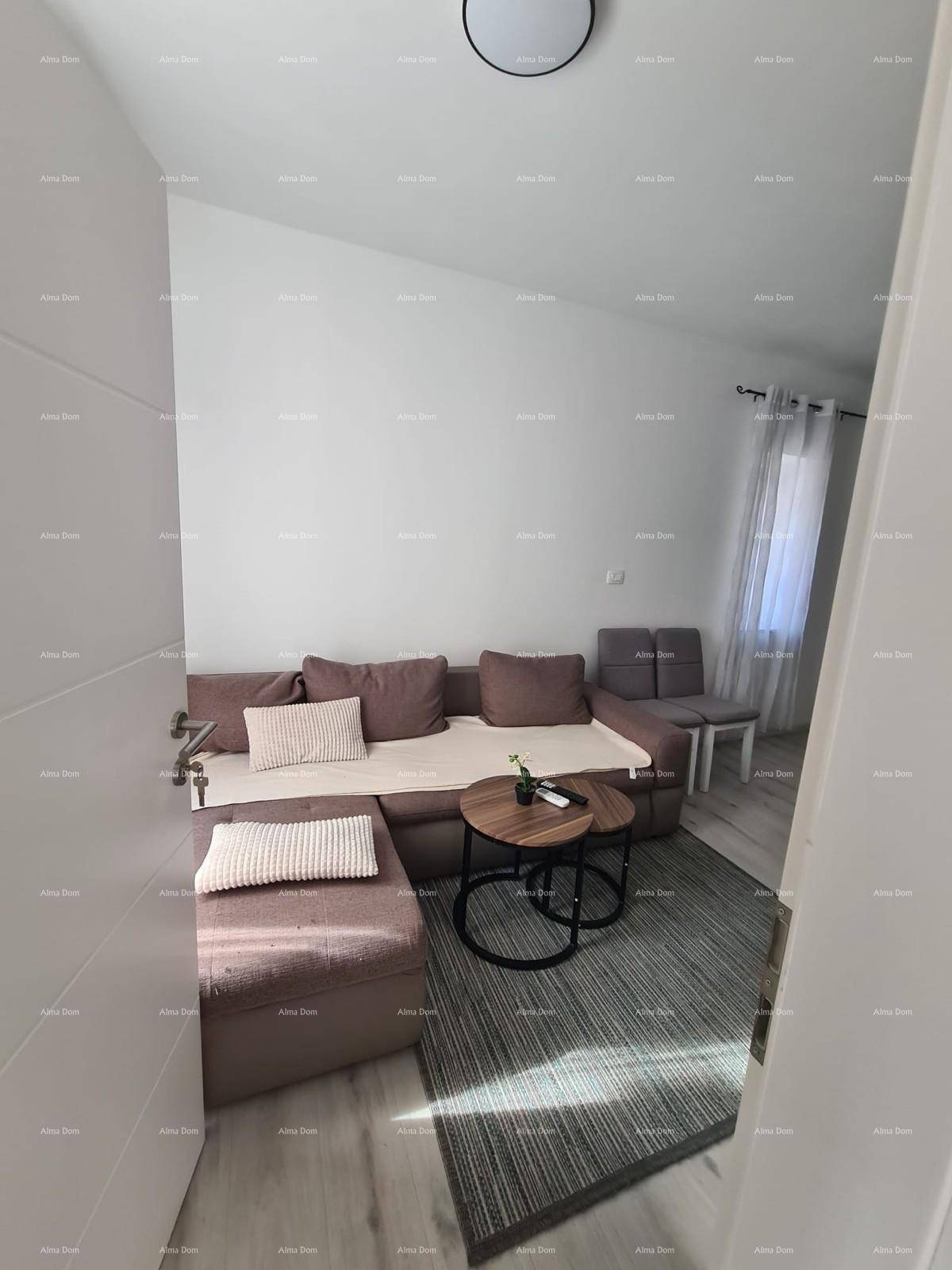 Wohnzimmer mit beigem Ecksofa und modernem Teppich, durch eine Tür sichtbar.