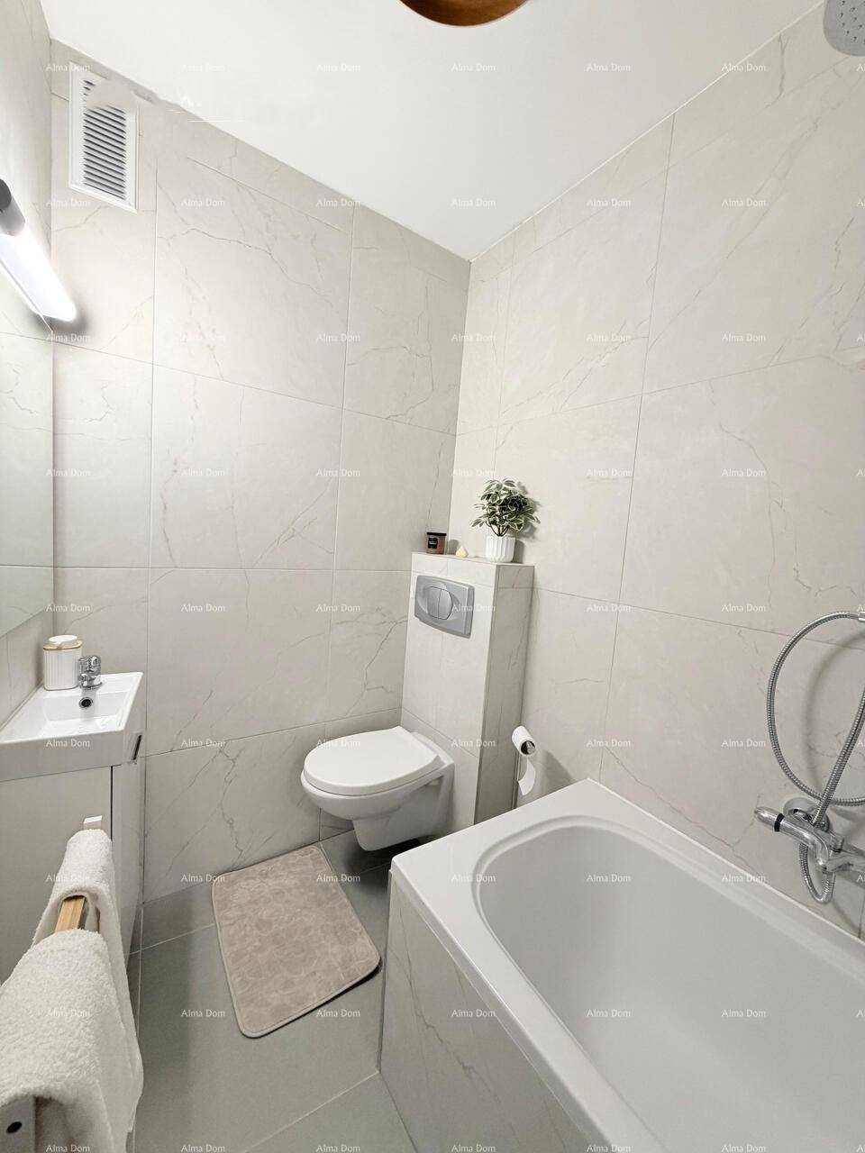 Helles Badezimmer mit Badewanne, Toilette, Waschbecken und modernen Wandfliesen.