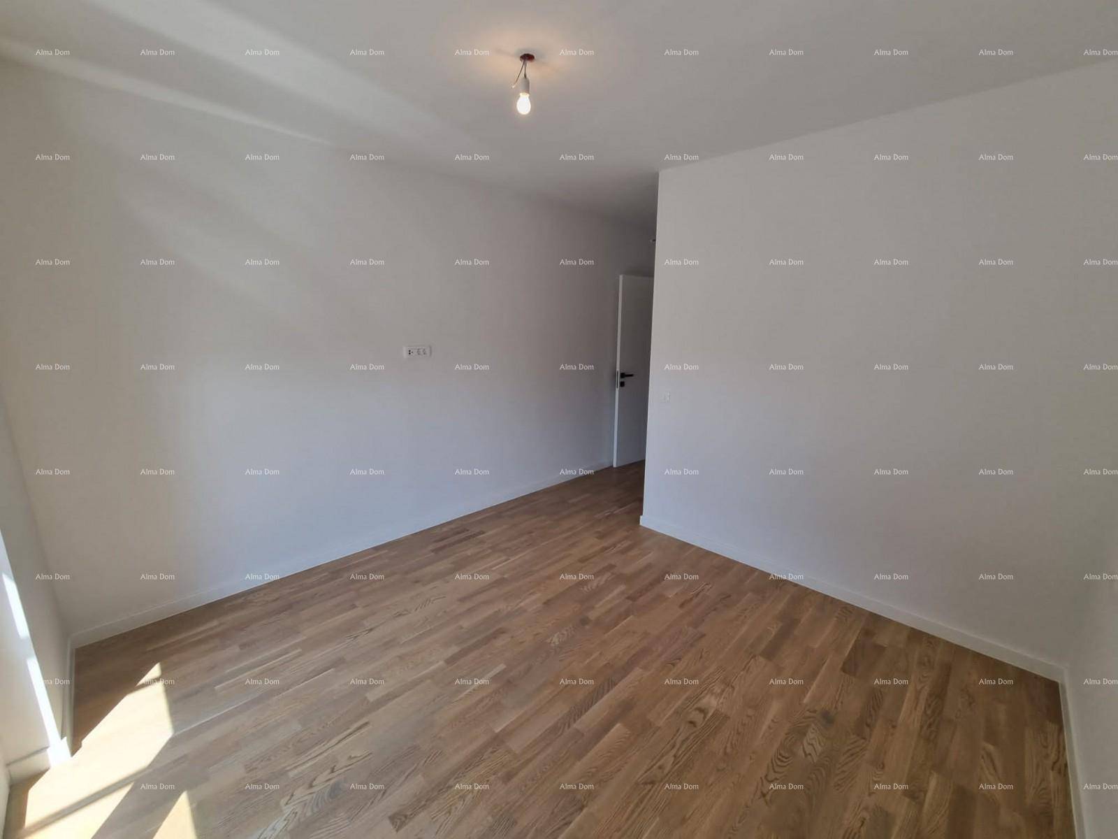 Helles Schlafzimmer mit Parkettboden und viel Tageslicht durch große Fenster.