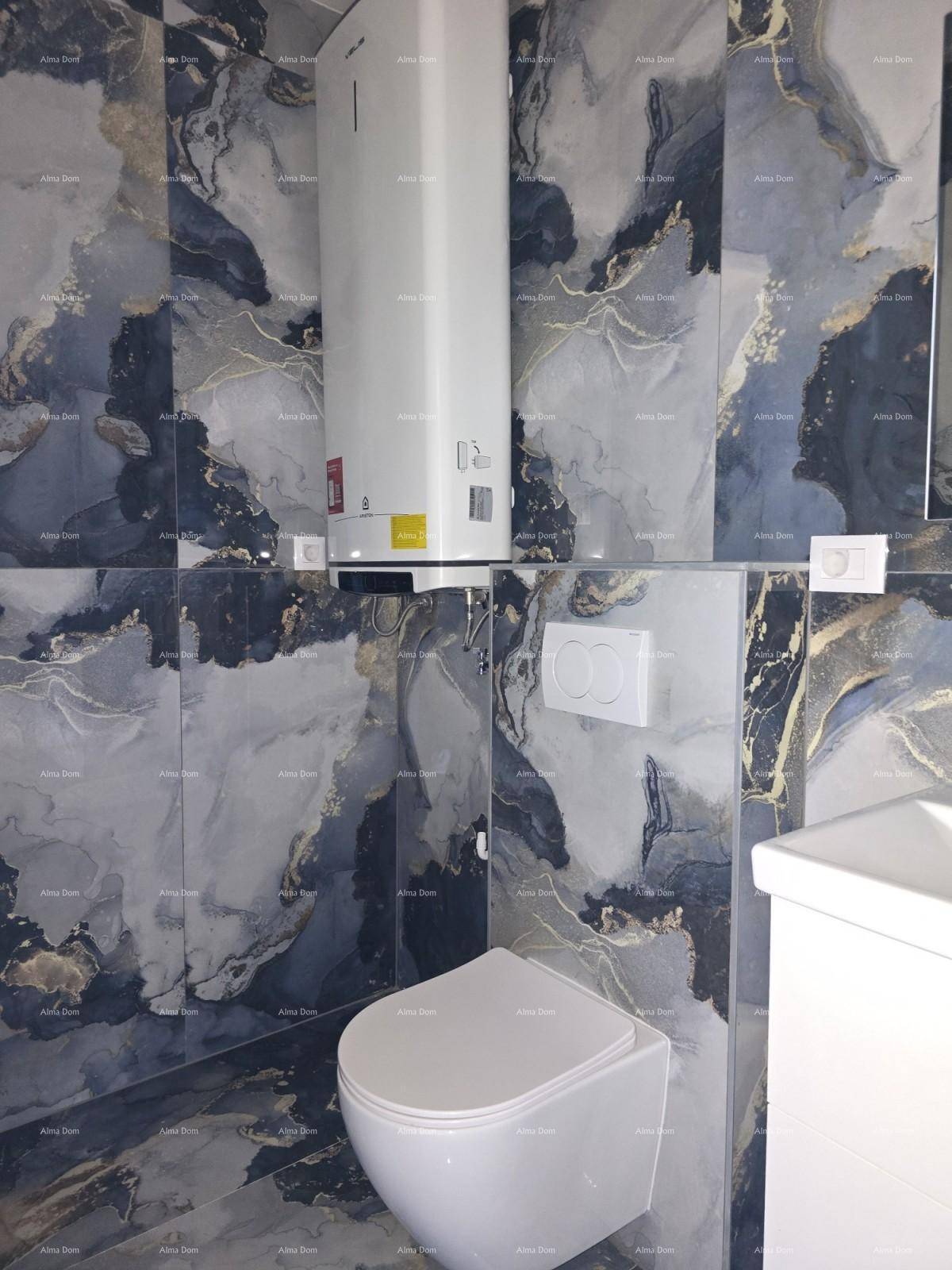 Modernes Badezimmer mit dunklen Marmorfliesen, wandhängendem WC und einem Warmwasserbereiter an der Wand.