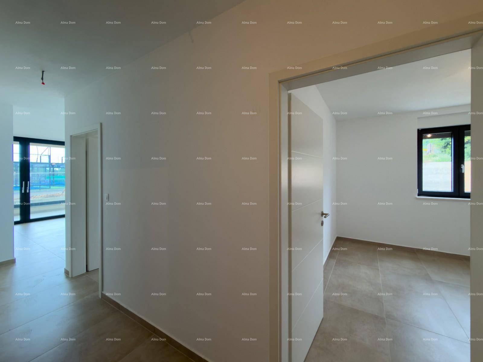 Heller Flur mit Zugang zu einem Zimmer mit Fenster und Blick auf den Wohnbereich mit großen Glasfronten.