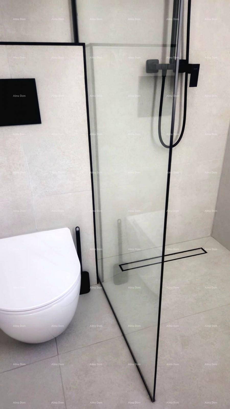 Duschbereich mit Glasabtrennung und wandhängendem WC in einem modern gefliesten Bad.