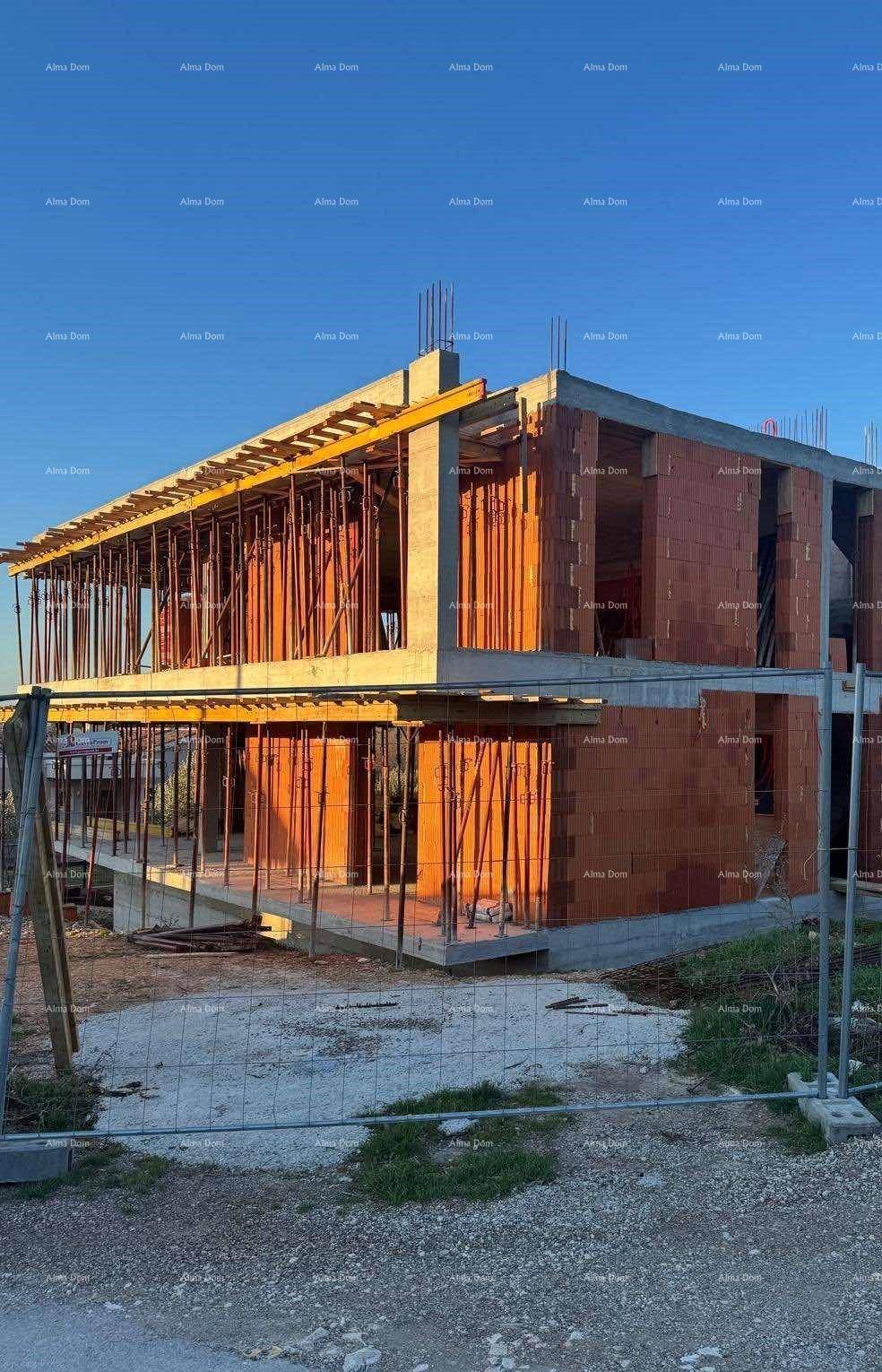 Rohbau eines modernen Gebäudes mit sichtbaren Betonelementen und Ziegelwänden.