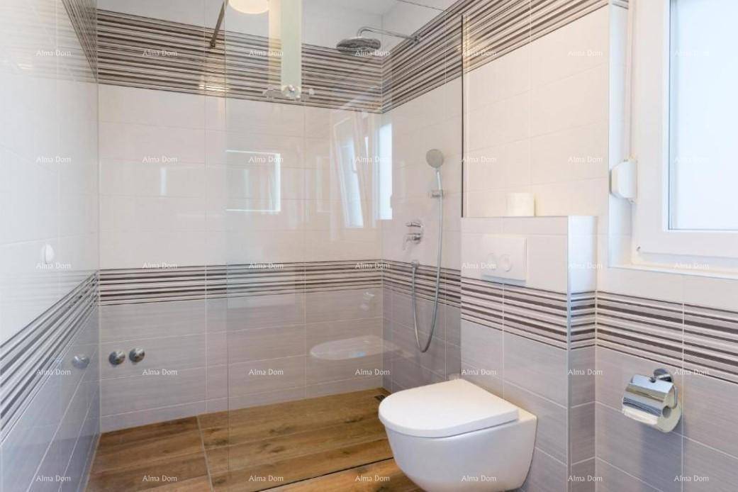 Modernes Badezimmer mit begehbarer Dusche, weiß-grauen Fliesen und einem Fenster.