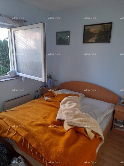 Schlafzimmer mit Doppelbett, orangefarbener Decke und geöffnetem Fenster für frische Luft.