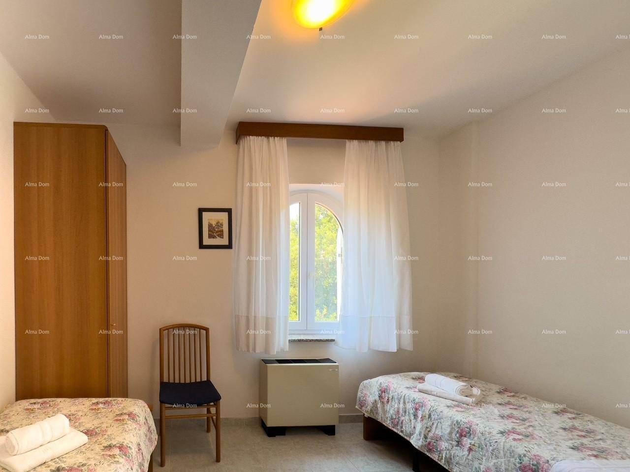 Schlafzimmer mit zwei Einzelbetten, Kleiderschrank und Fenster mit Vorhängen, hell und einfach.