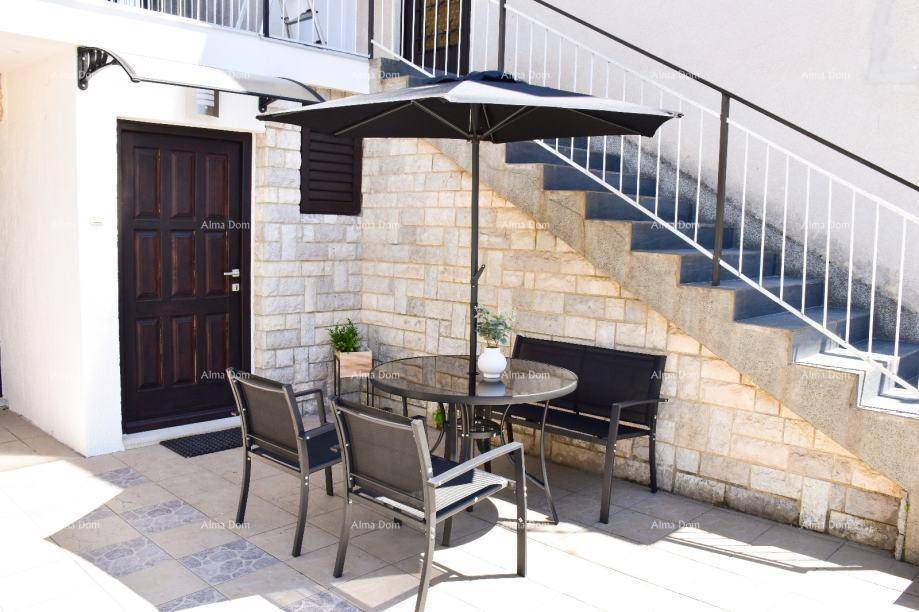 Gemütliche Terrasse mit Sitzgelegenheiten, Sonnenschirm und Steinfassade, ideal zum Entspannen.