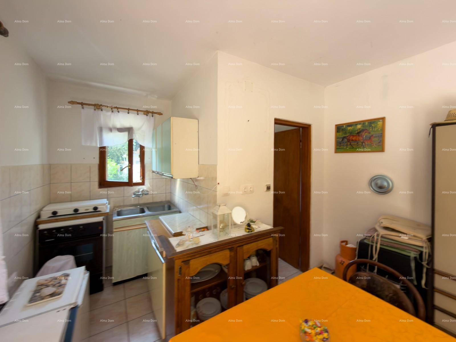 Einfache Küche mit Herd, Spüle und Holzschrank, funktional für den täglichen Gebrauch.