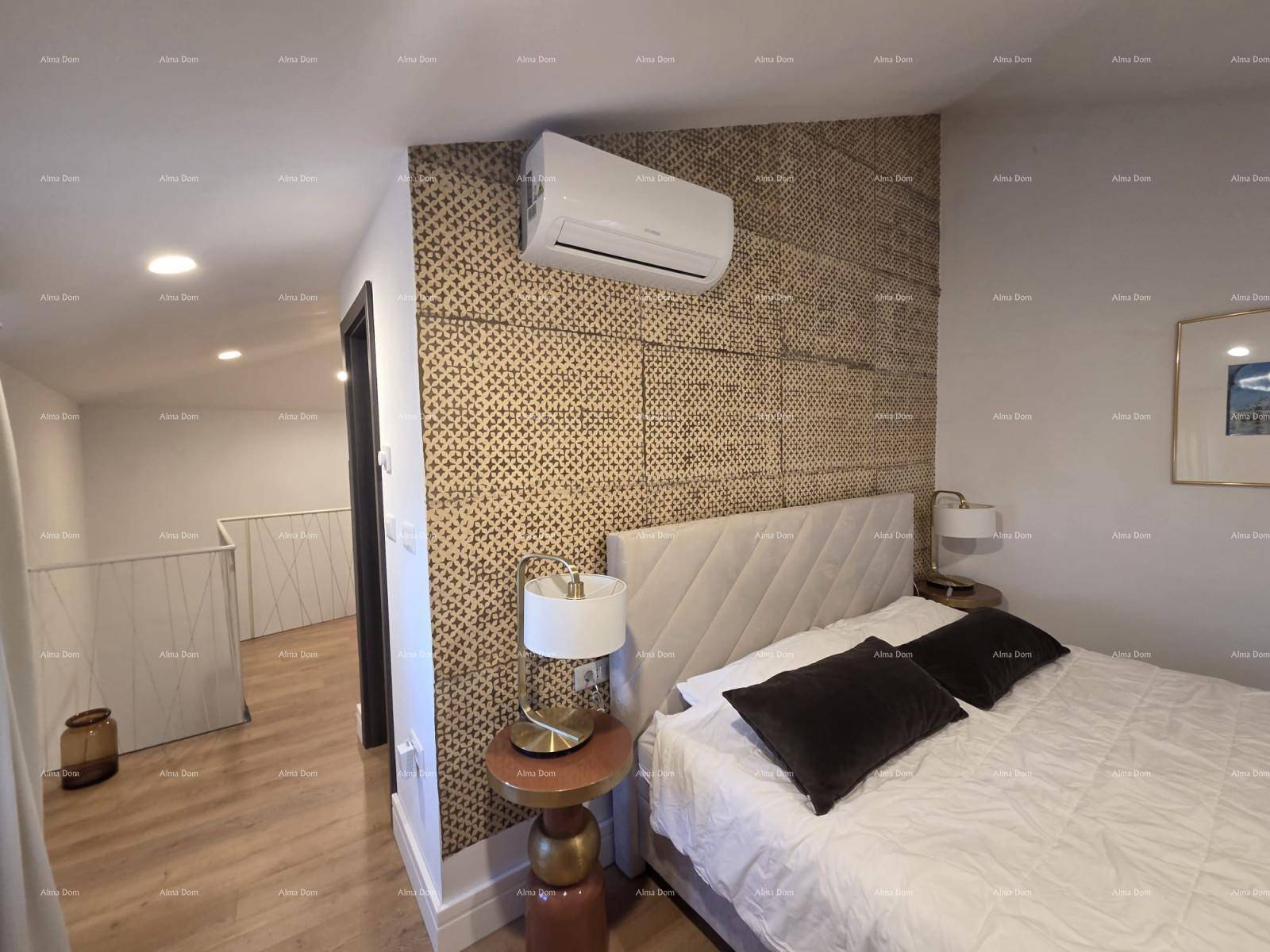 Helles Schlafzimmer mit gemusterter Wand, Klimaanlage und Zugang zu einem offenen Treppenbereich.