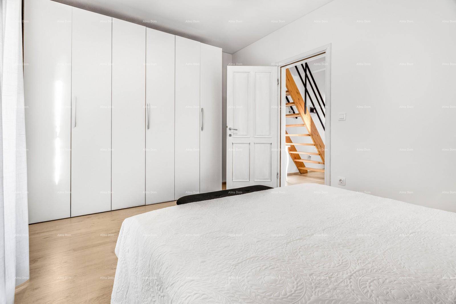 Schlafzimmer mit großem weißen Kleiderschrank und hellem Holzboden.