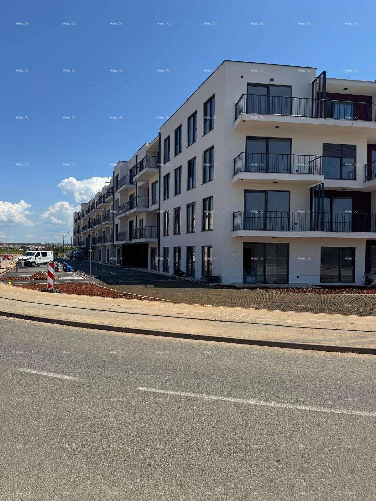 Lange Fassade eines modernen Wohnkomplexes mit Balkonen und Straßenansicht.