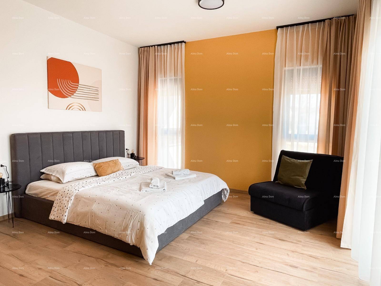Komfortables Schlafzimmer mit Holzboden, Doppelbett und einem Sessel am Fenster.