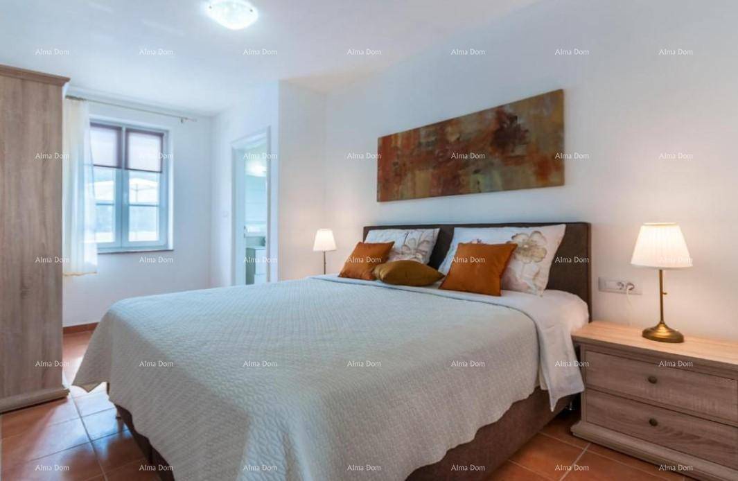 Helles Schlafzimmer mit Doppelbett, Nachttischen und einem Fenster, das viel Licht hereinlässt.