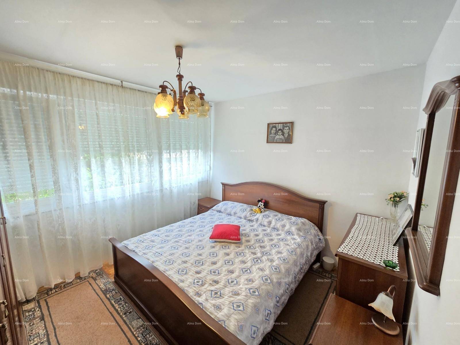 Schlafzimmer mit Doppelbett, klassischen Holzmöbeln und Fenster mit Vorhängen.
