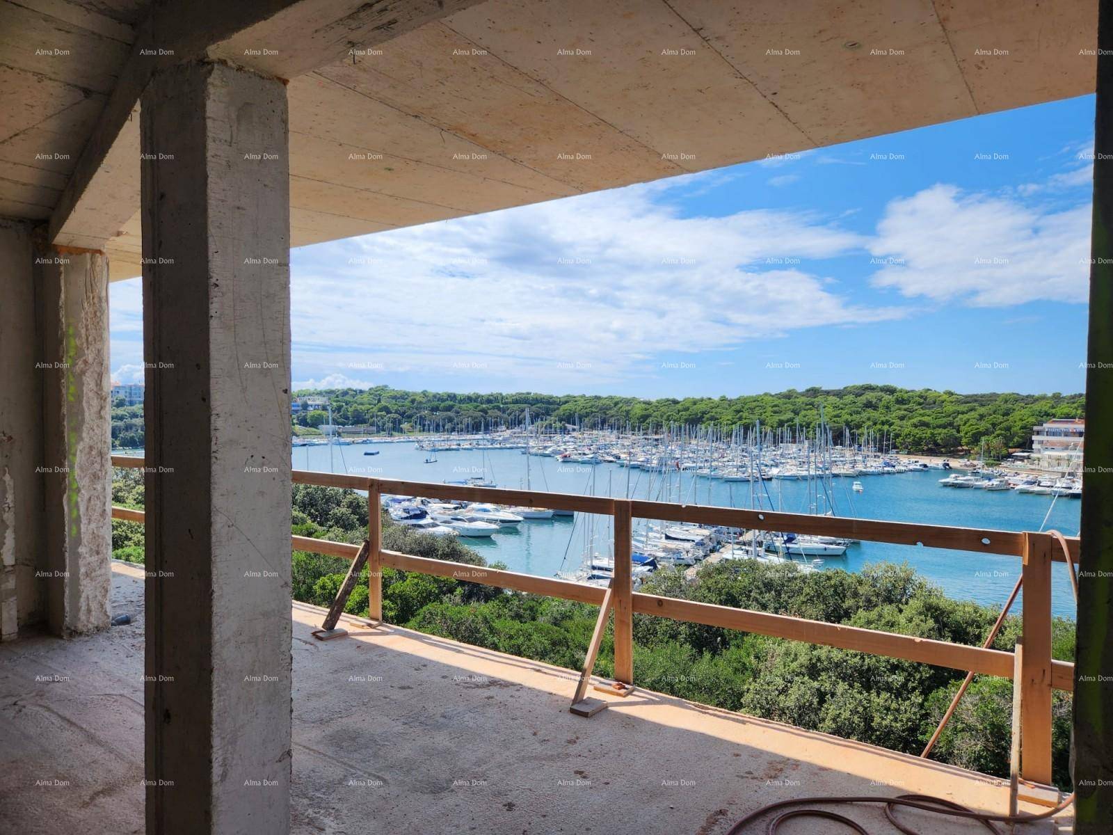 Rohbau-Innenraum mit Betonoberflächen und weitem Ausblick auf den Yachthafen und die grüne Landschaft.