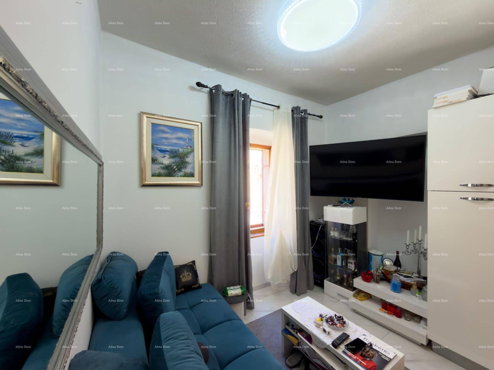 Helles Wohnzimmer mit blauem Sofa, großem Spiegel und Fenster.