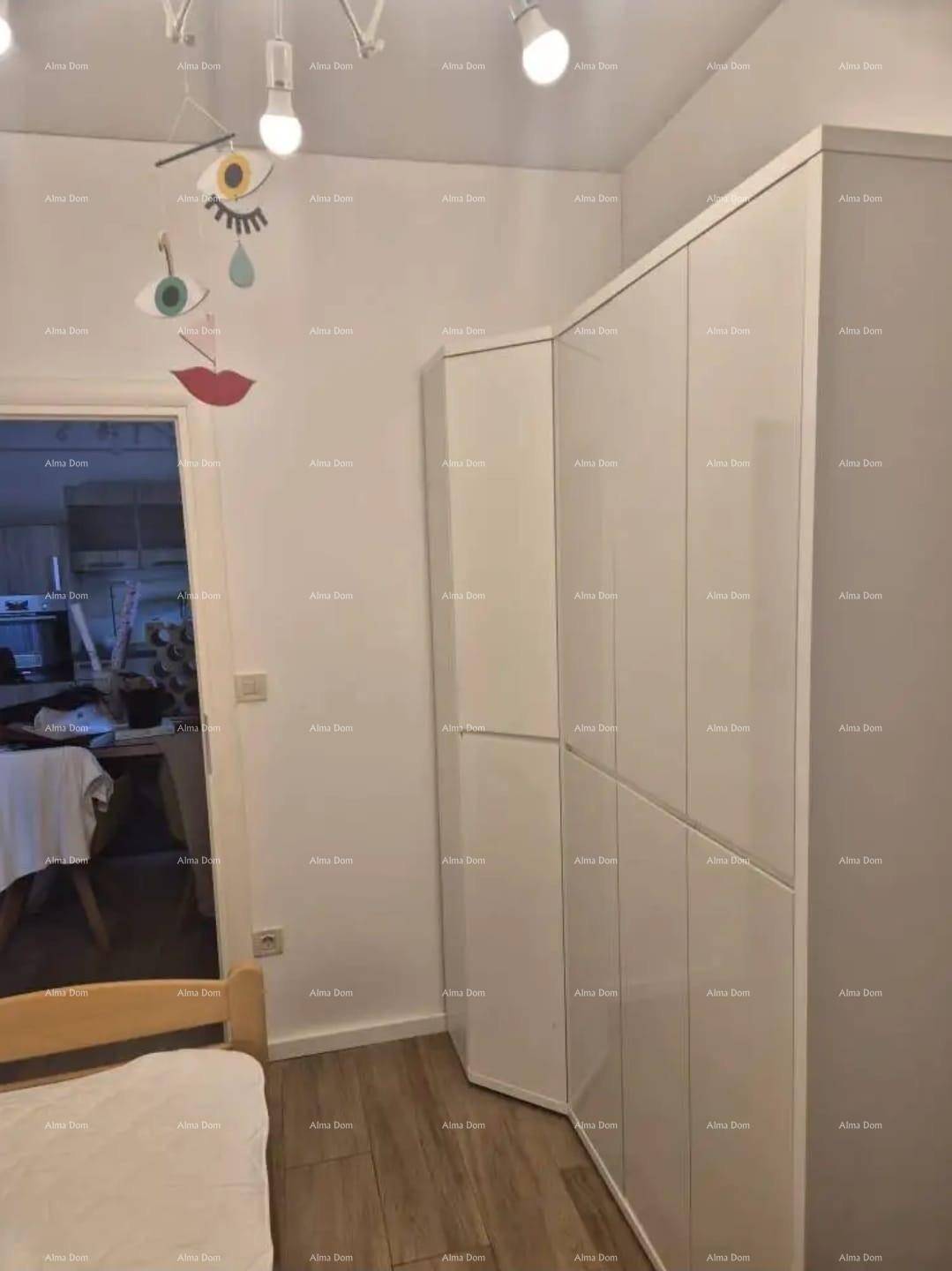 Schlafzimmer mit modernen weißen Einbauschränken und Holzboden.