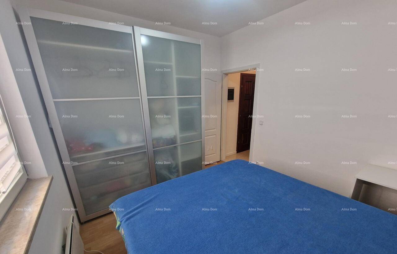Schlafzimmer mit großem Kleiderschrank, Doppelbett und Holzboden.