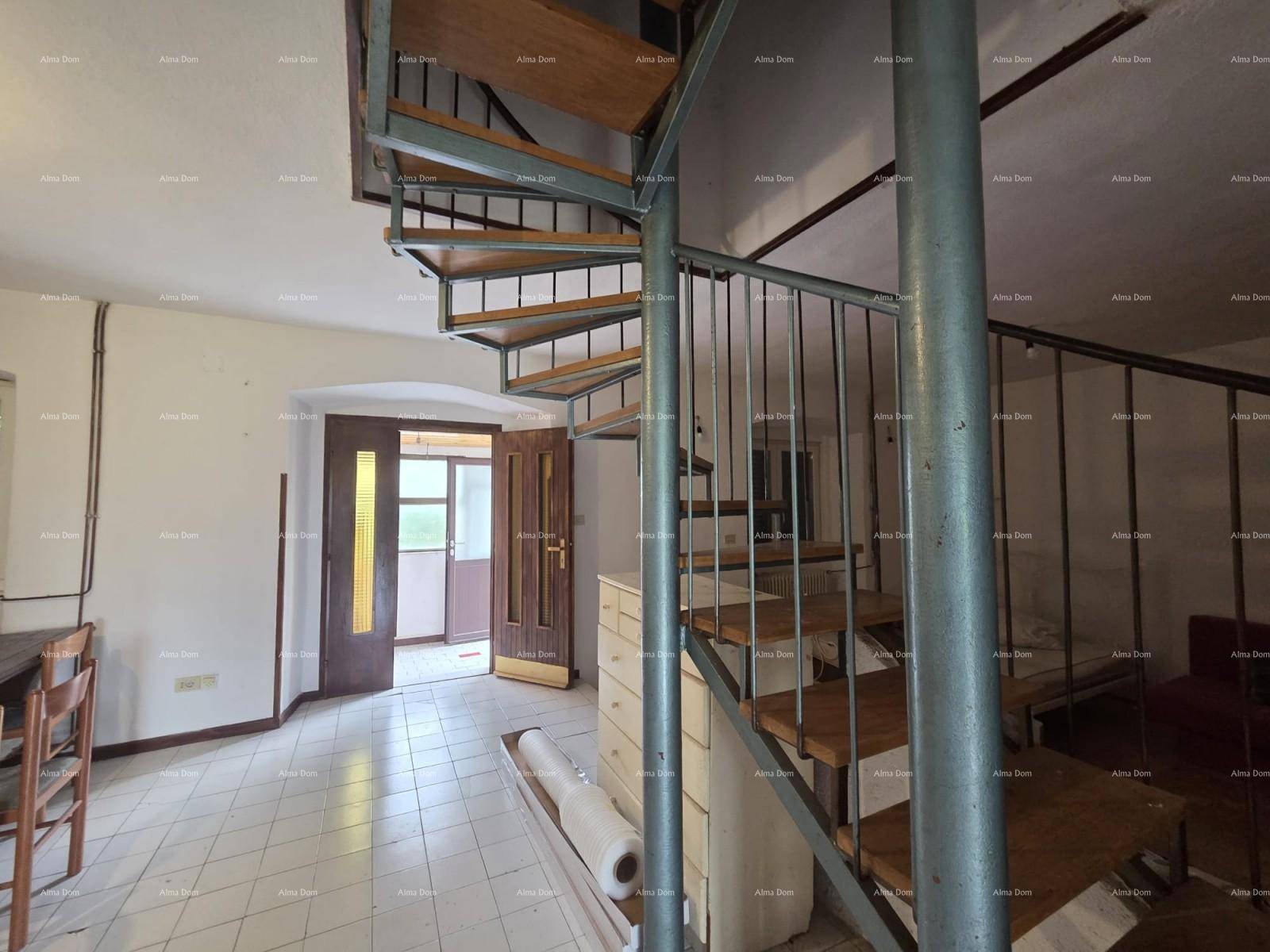 Innenraum mit einer markanten Wendeltreppe, Fliesenboden und Zugang zu einem weiteren Zimmer.