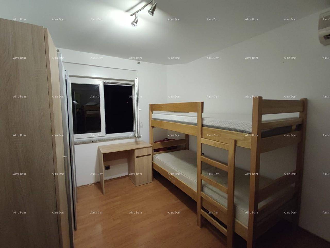 Kinderzimmer mit Etagenbett, Schreibtisch und Kleiderschrank.