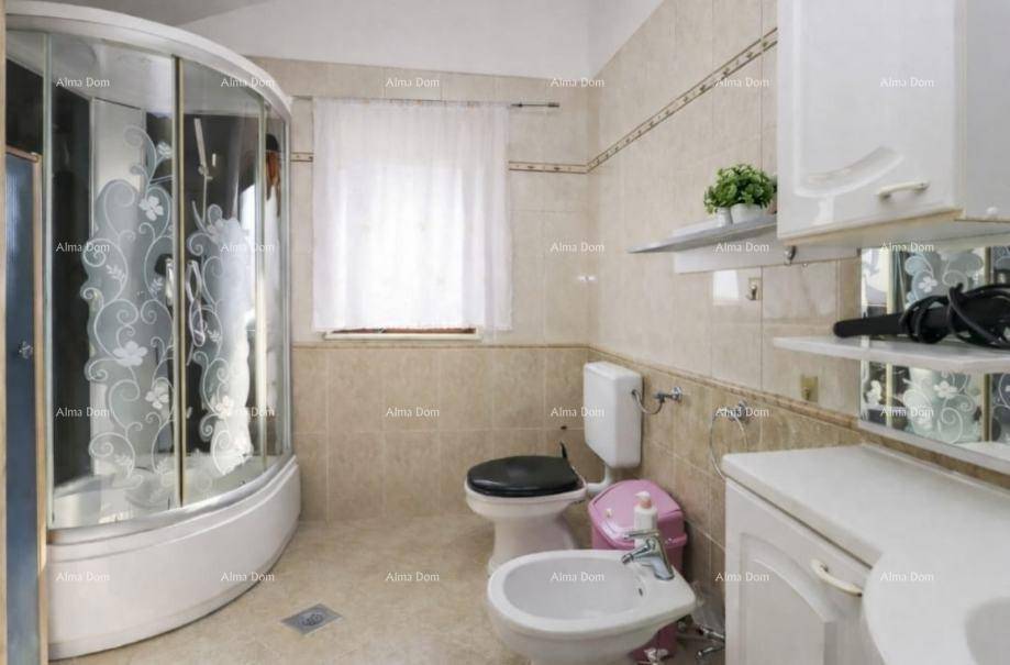Helles Badezimmer mit Duschkabine, Toilette, Bidet und Fenster für natürliche Belüftung.