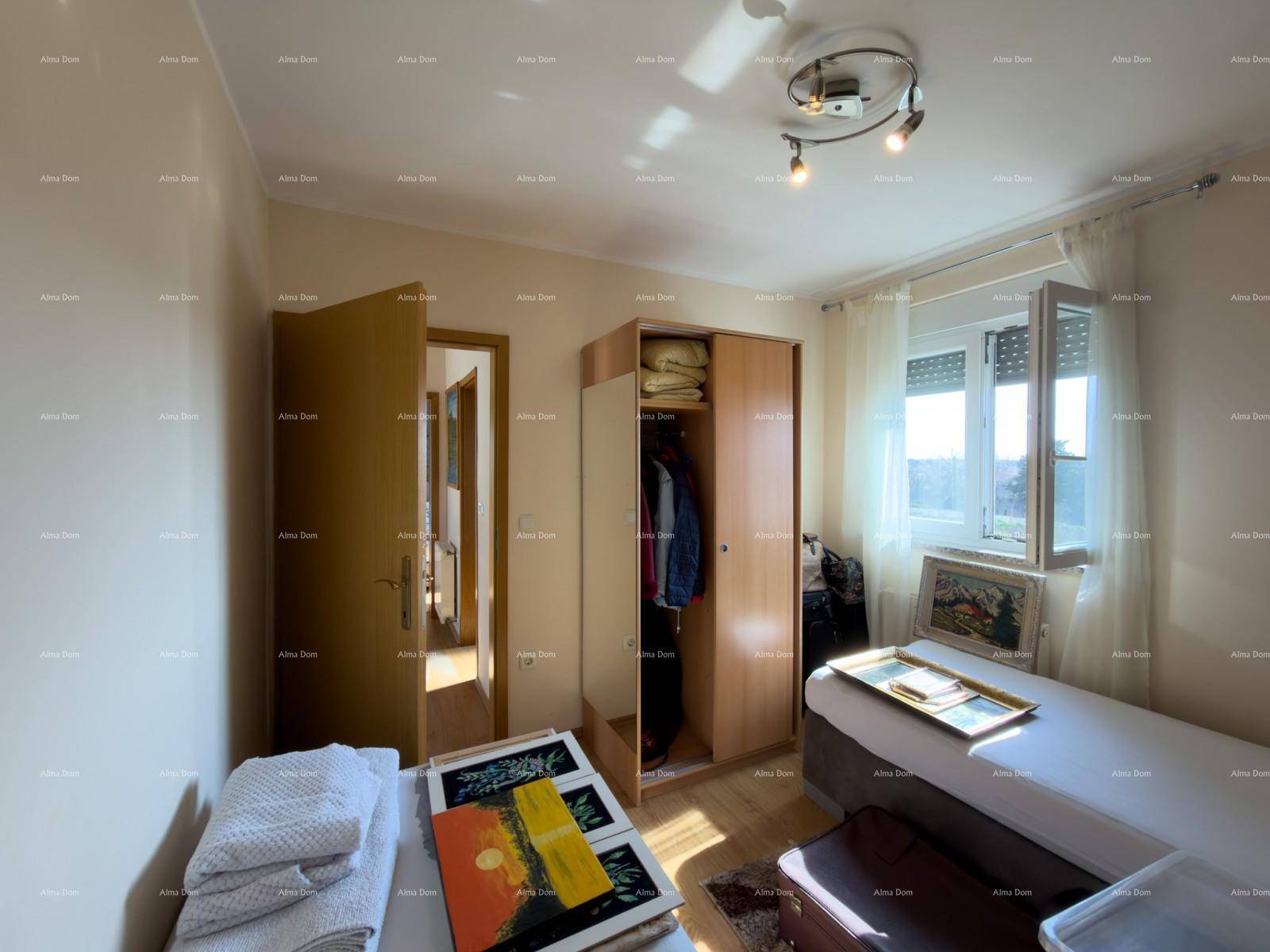 Schlafzimmer mit Einzelbetten, Kleiderschrank und Blick ins Grüne durch das Fenster.