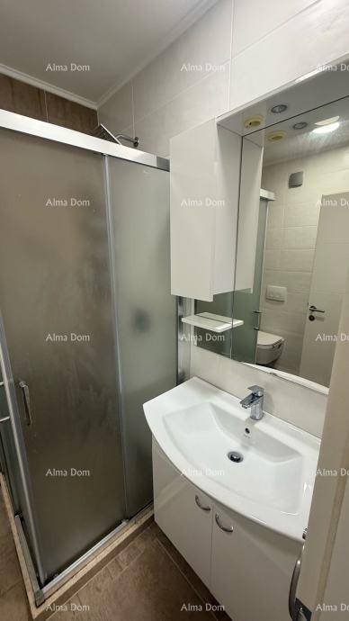 Badezimmer mit Duschkabine, Waschbecken und Spiegelschrank.