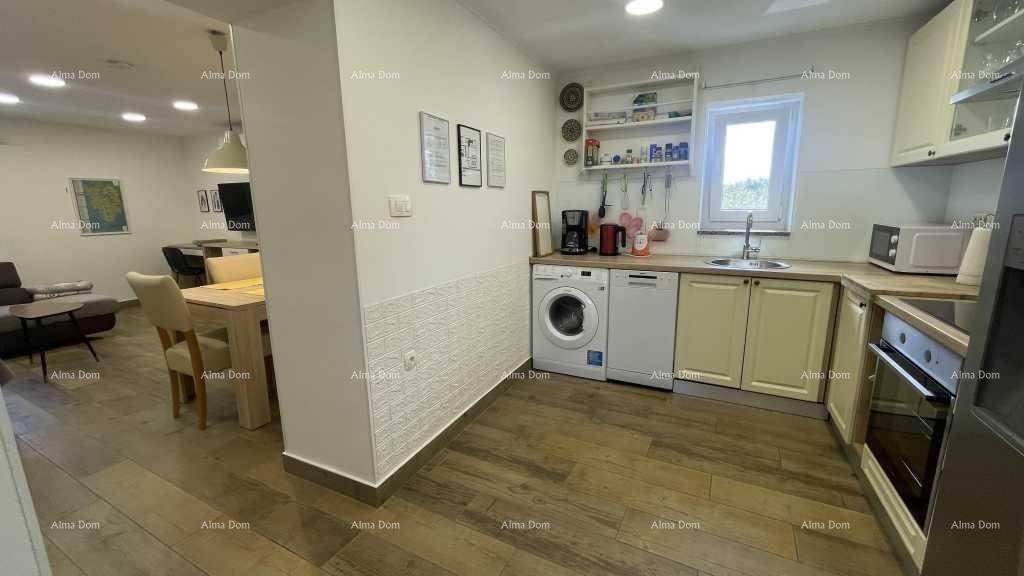 Offene Küche mit Essbereich, ausgestattet mit modernen Geräten und hellem Holzfußboden.