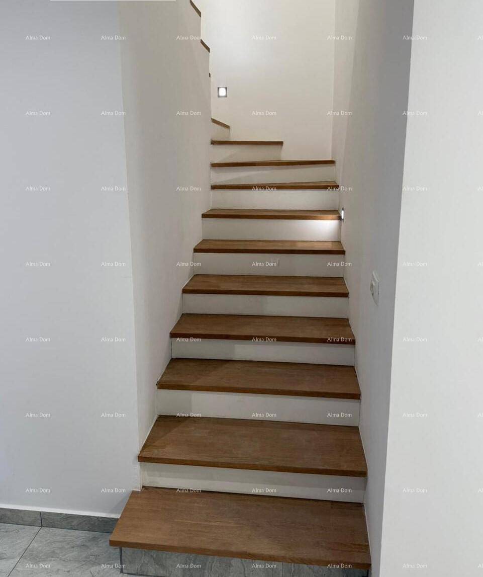 Moderne Holztreppe mit schwebenden Stufen und weiß gestrichenen Wänden in einem Flur.