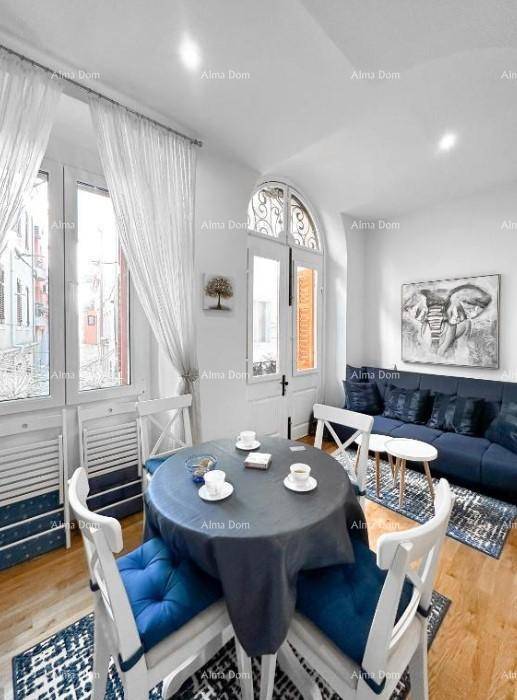 Gemütlicher Essbereich mit rundem Tisch und blauen Akzenten, neben einem Sofa und Fenster.