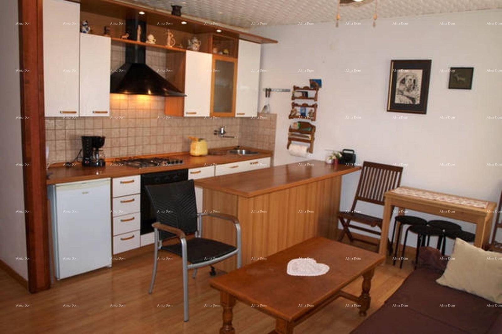 Funktionale Küche mit Holztheke, weißen Schränken und Essbereich.