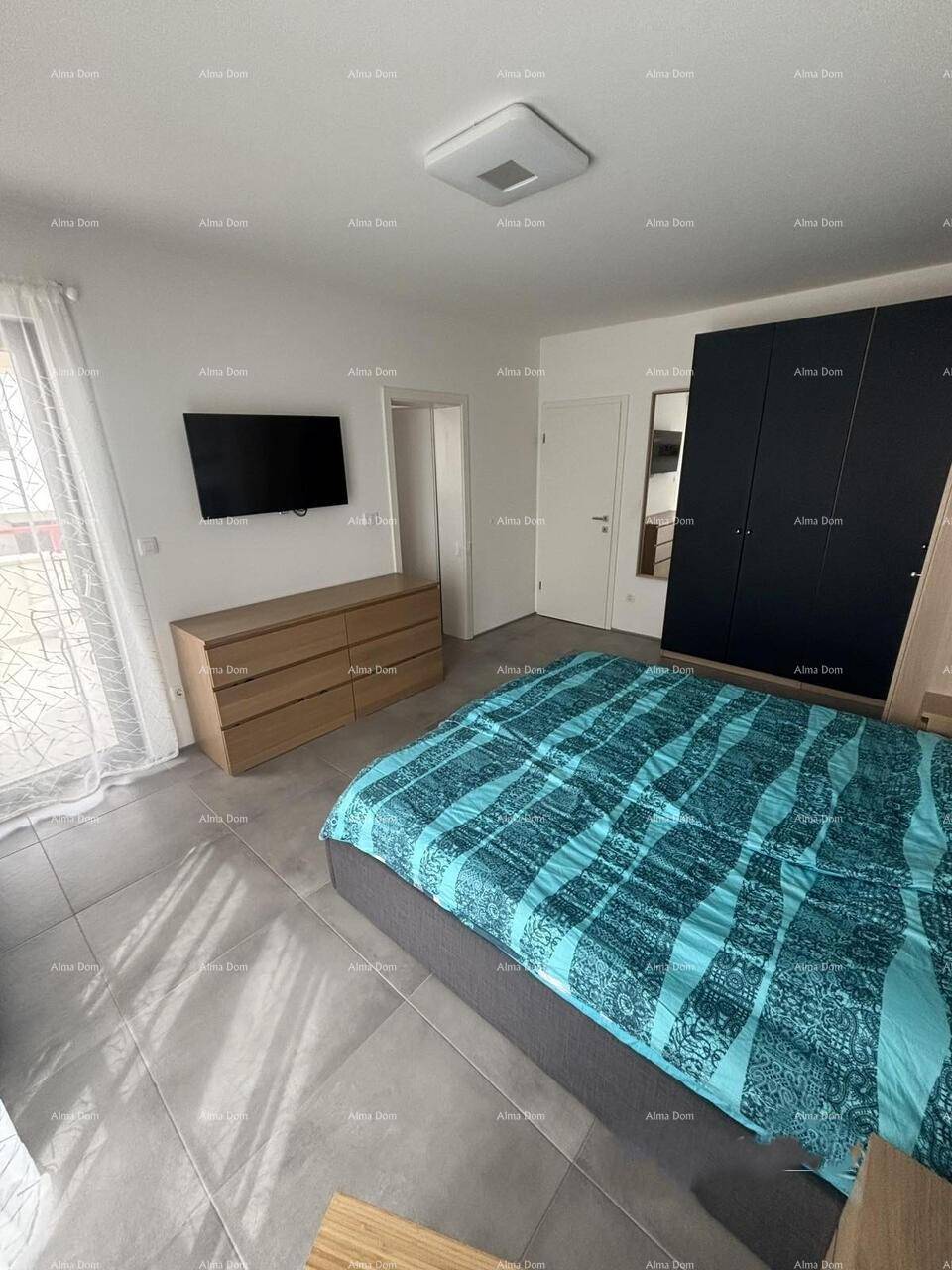 Helles Schlafzimmer mit Doppelbett, Fliesenboden und großem Kleiderschrank.