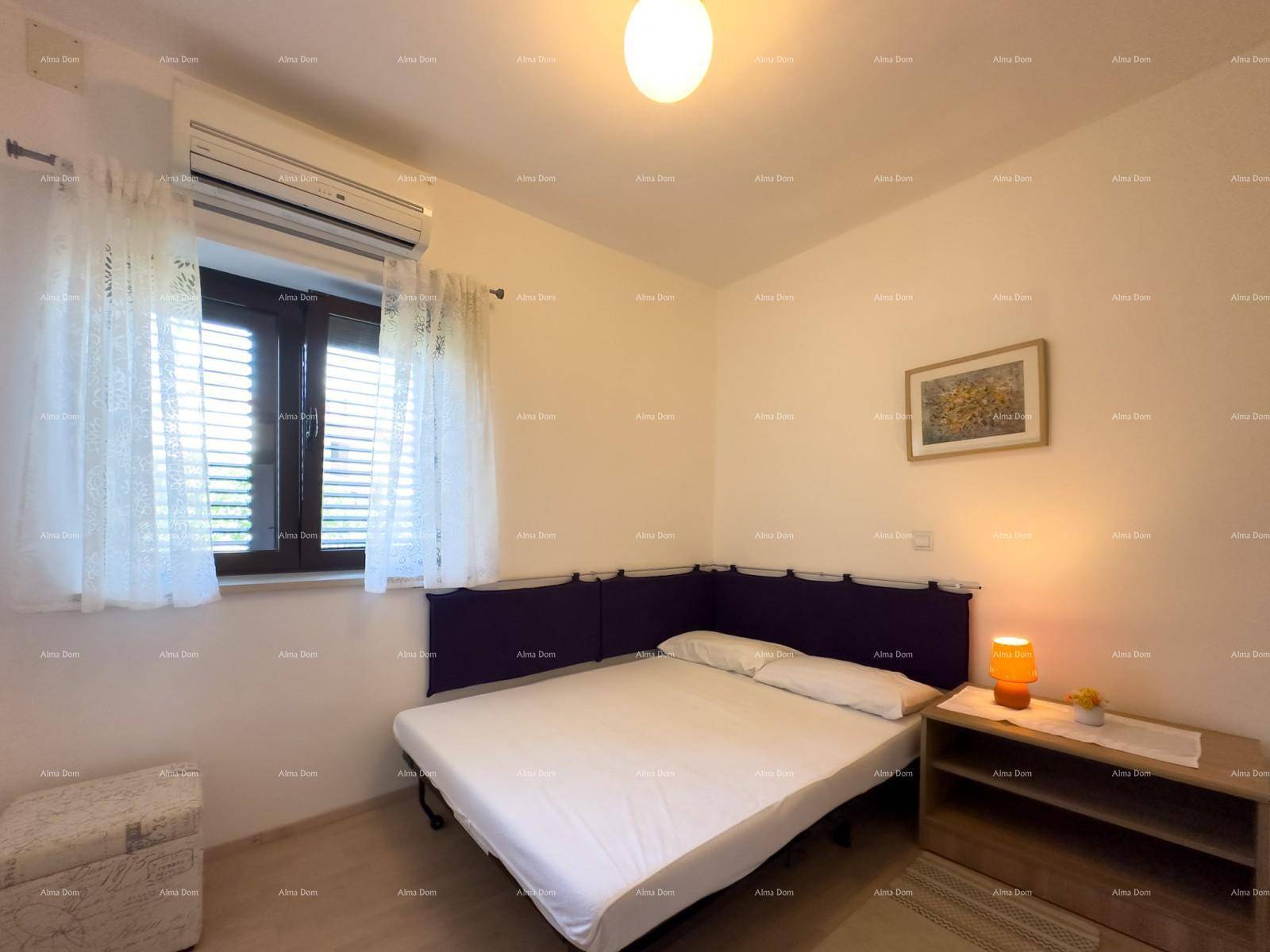 Schlafzimmer mit Doppelbett, Klimaanlage und einem kleinen Nachttisch mit Lampe.