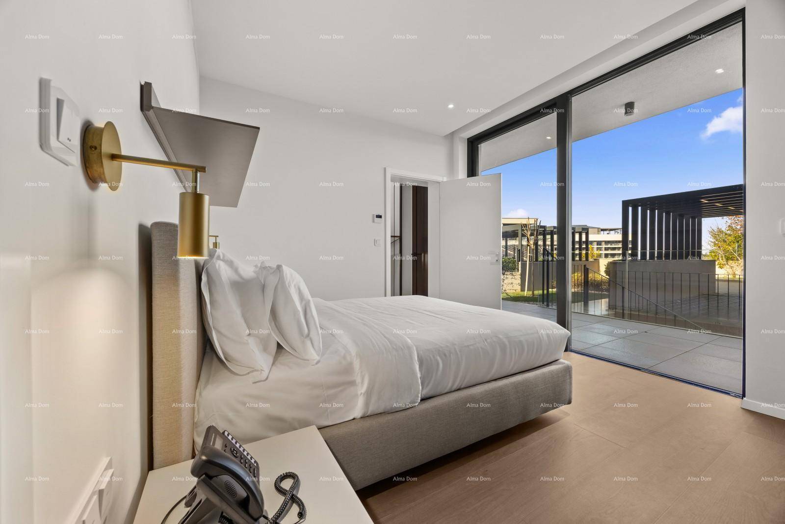 Helles Schlafzimmer mit Zugang zu einer Terrasse durch große Glasschiebetüren und Holzboden.