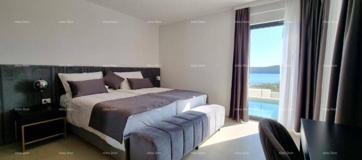 Modernes Schlafzimmer mit großem Bett, dunklen Vorhängen und direktem Blick auf das Meer und den Pool.