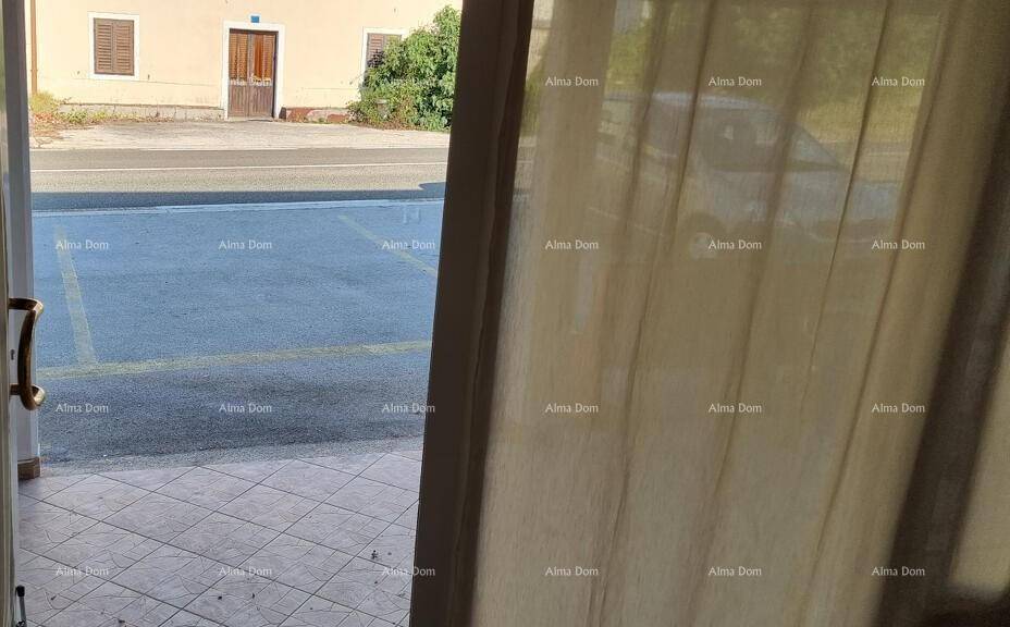 Blick von einem Innenraum durch eine offene Tür auf die Straße und den Außenbereich.