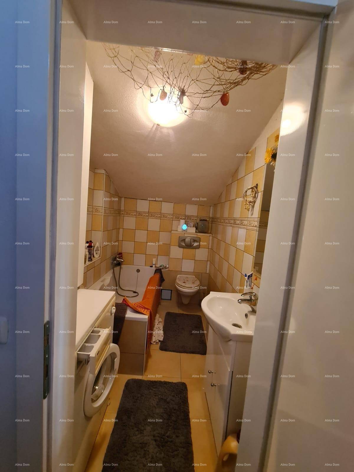 Kleines Badezimmer im Dachgeschoss mit Waschbecken, Toilette und Waschmaschine.