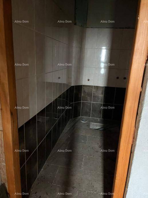 Badezimmer im Rohbau mit zweifarbigen Fliesen an Wänden und Boden, bereit für die Installation.