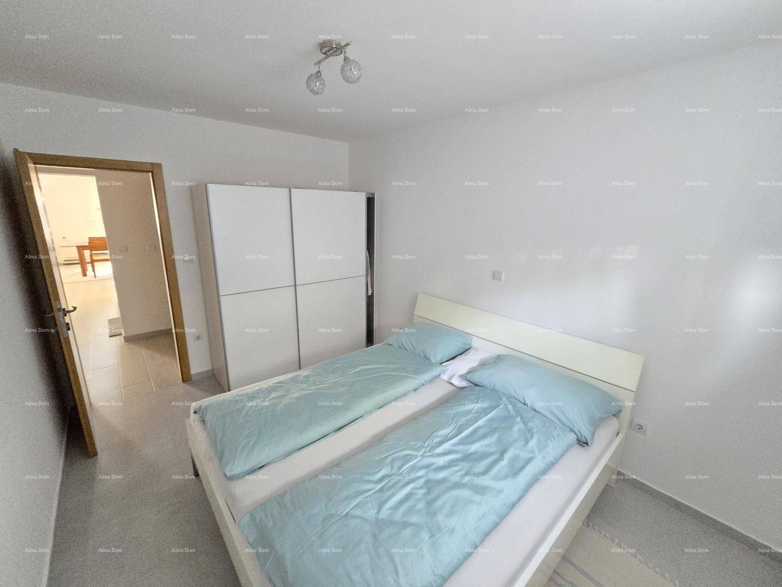 Schlafzimmer mit Doppelbett und hellblauer Bettwäsche, weißem Kleiderschrank und Fliesenboden.
