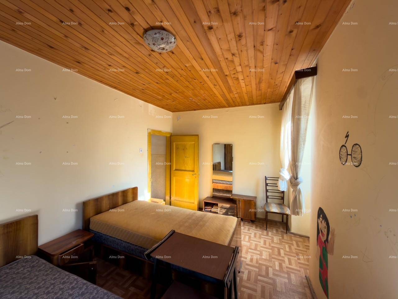 Schlafzimmer mit Holzdecke, zwei Betten und einem Schminktisch, hell und einfach eingerichtet.