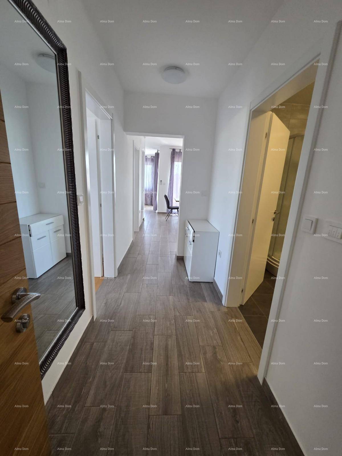 Heller Flur mit Holzoptik-Fliesenboden, weißen Wänden und Zugang zu weiteren Räumen.