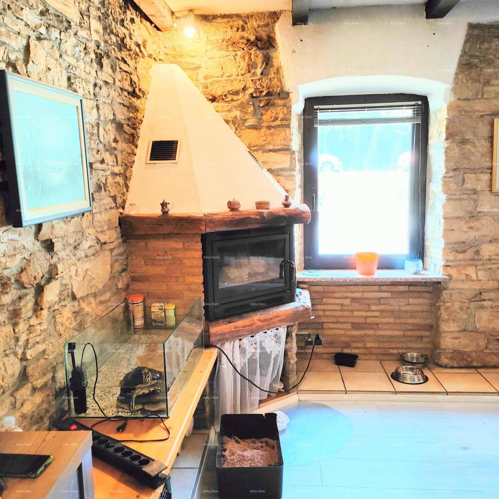 Gemütlicher Wohnbereich mit integriertem Kamin, rustikalen Steinwänden und kleinem Fenster für natürliches Licht.
