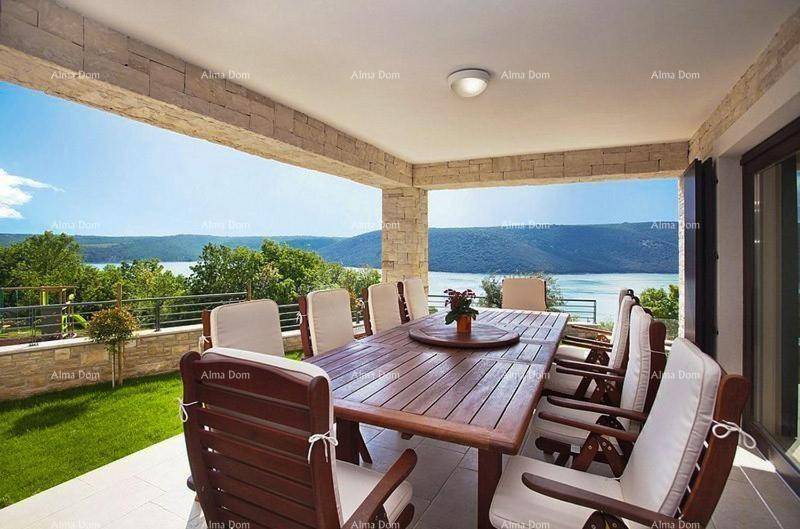 Überdachte Terrasse mit großem Esstisch und Stühlen, bietet einen wunderschönen Seeblick.