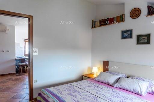 Schlafzimmer mit Zugang zu einem weiteren Raum, ausgestattet mit einem Doppelbett und Dachschrägen.