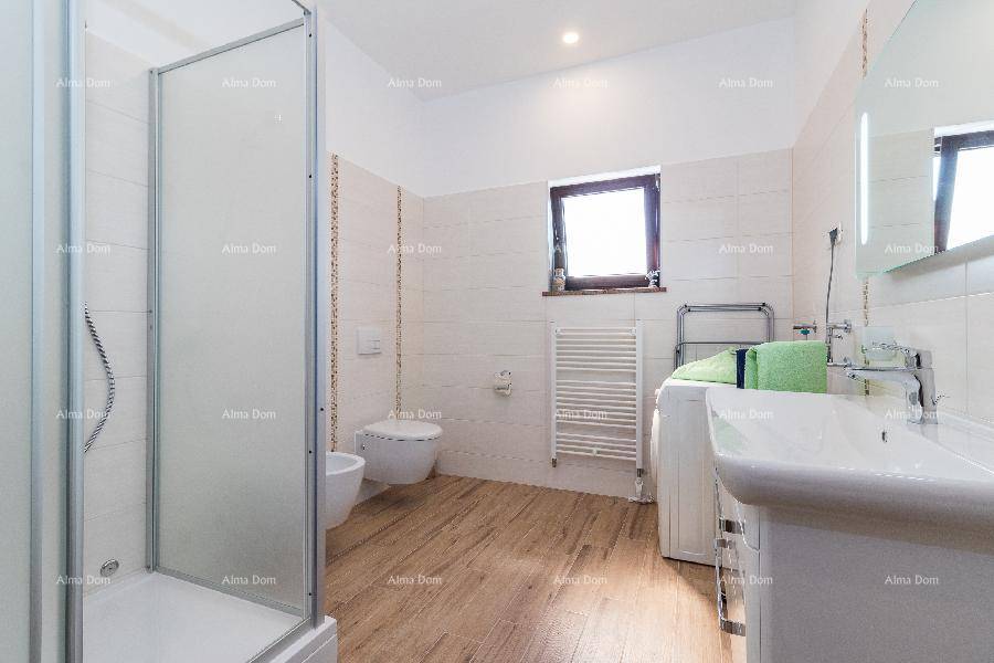 Helles Badezimmer mit Duschkabine, WC, Bidet, Waschbecken und Fenster, ausgestattet mit einer Waschmaschine.