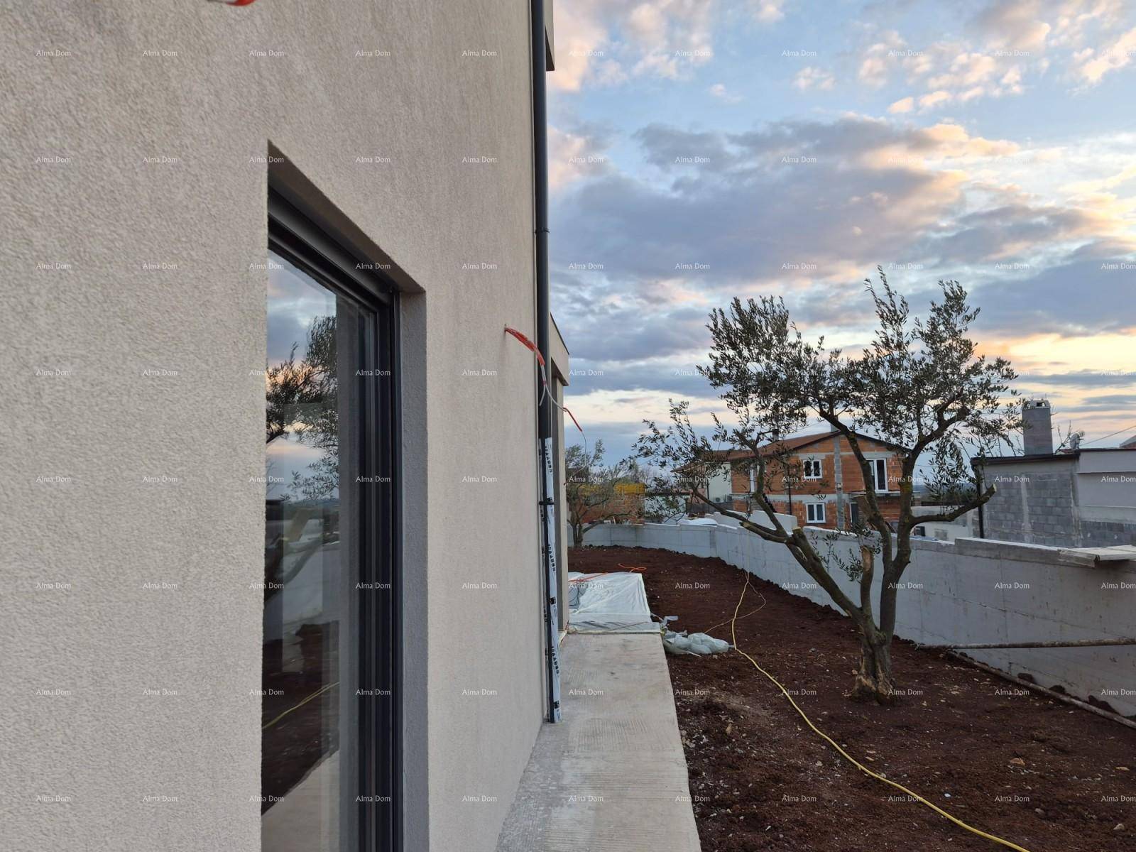 Seitenansicht eines modernen Hauses im Bau mit Fenster und unfertigem Gelände bei Sonnenuntergang.