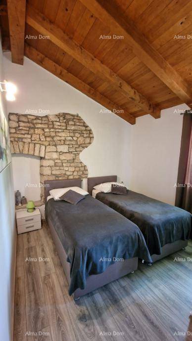 Schlafzimmer mit zwei Einzelbetten, Holzbalkendecke und einer rustikalen Steinwand, die Gemütlichkeit ausstrahlt.