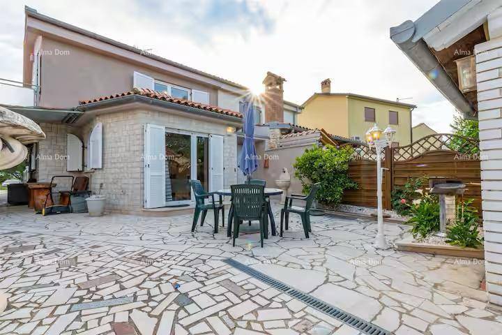 Große gepflasterte Terrasse mit Gartenmöbeln und Blick auf das Wohnhaus.