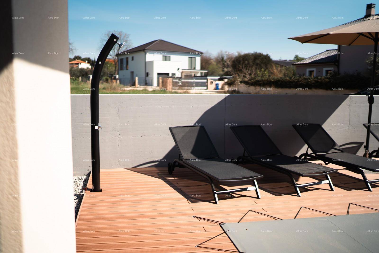 Holzterrasse mit Sonnenliegen und Außendusche, perfekt für heiße Sommertage.